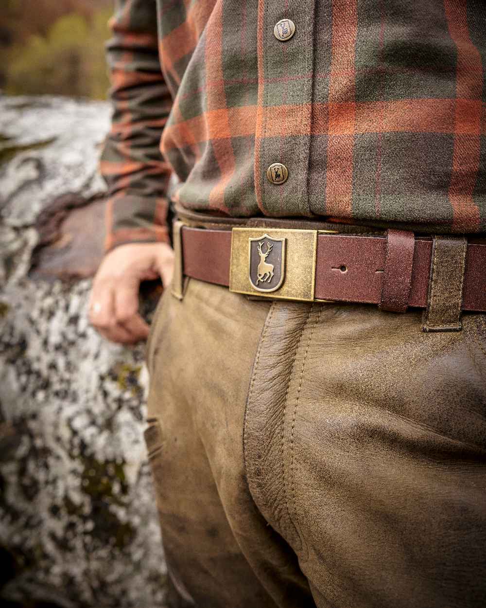 Cognac Brown coloured Deerhunter Deer Buckle Leather Belt on blurry background 