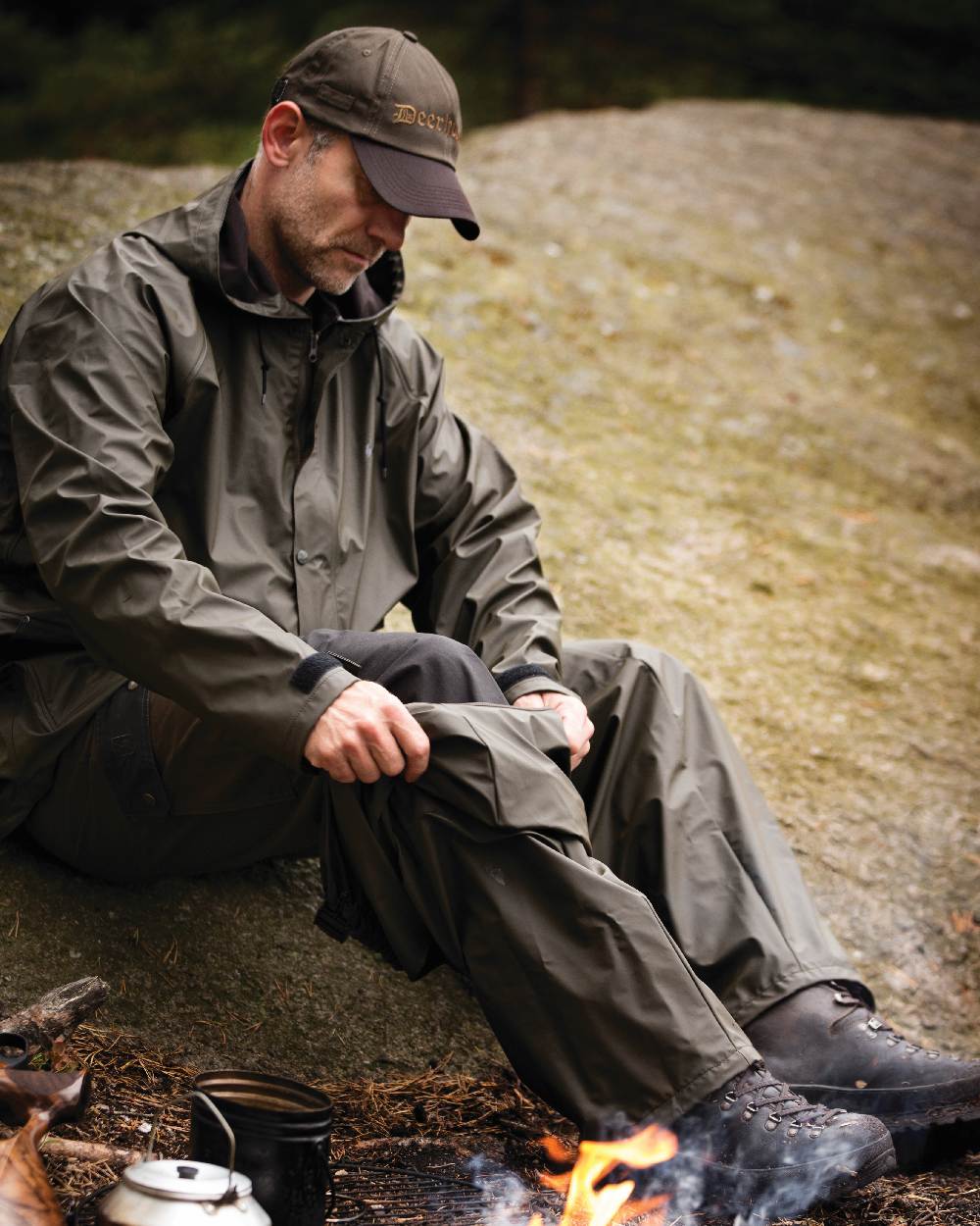 Art Green coloured Deerhunter Hurricane Rain Jacket on rock background 