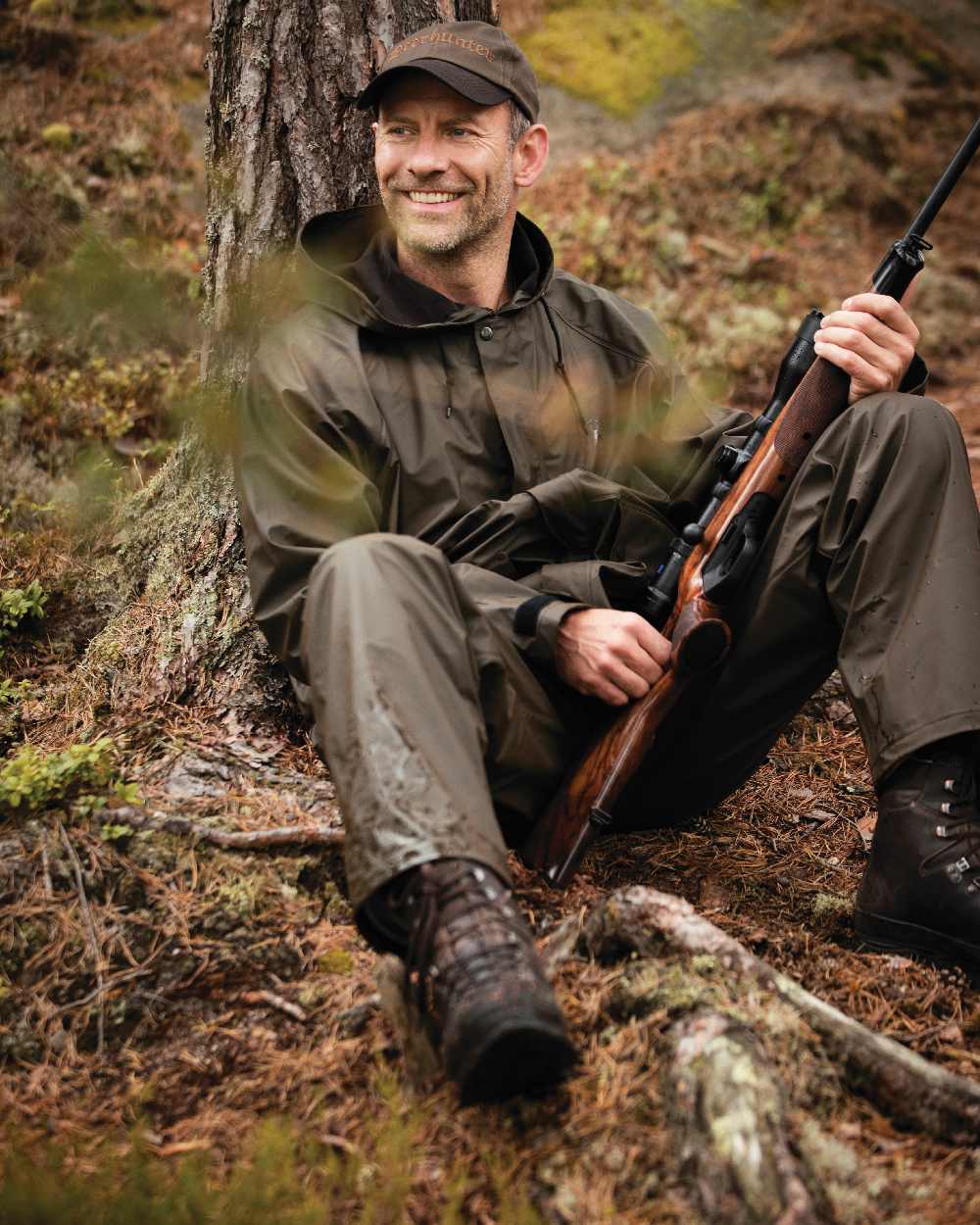 Art Green coloured Deerhunter Hurricane Rain Jacket on forest background 