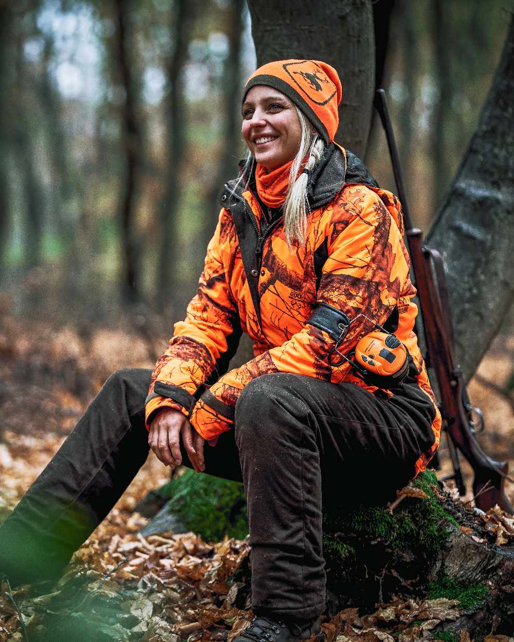 Orange coloured Deerhunter Logo Neck Tube on forest background