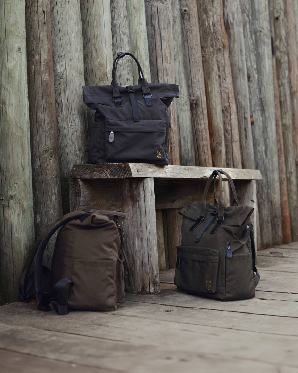 Black Ink coloured Deerhunter Rolltop Backpack on wooden wall background
