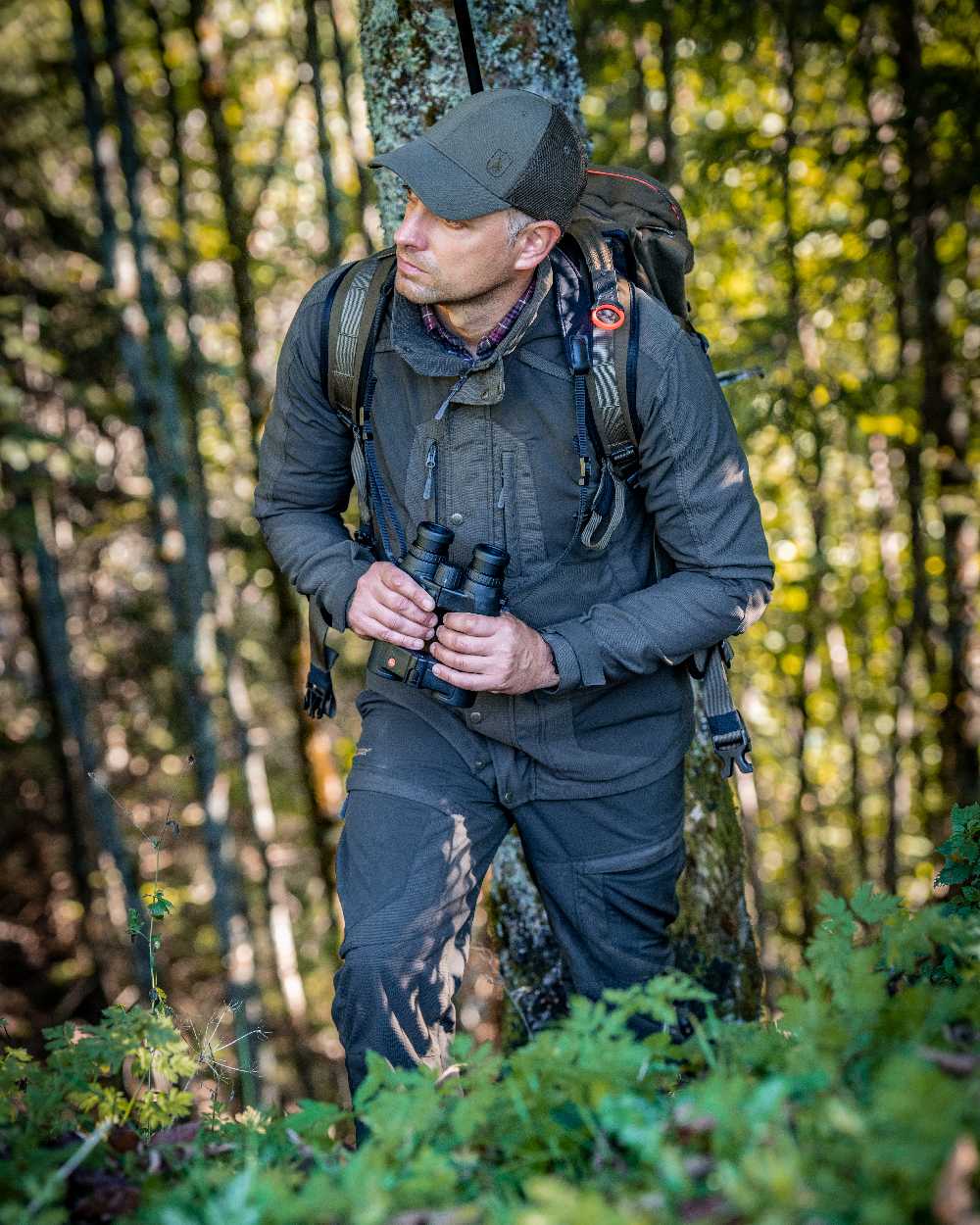 Palm Green coloured Deerhunter Strike Extreme Trousers on forest background 