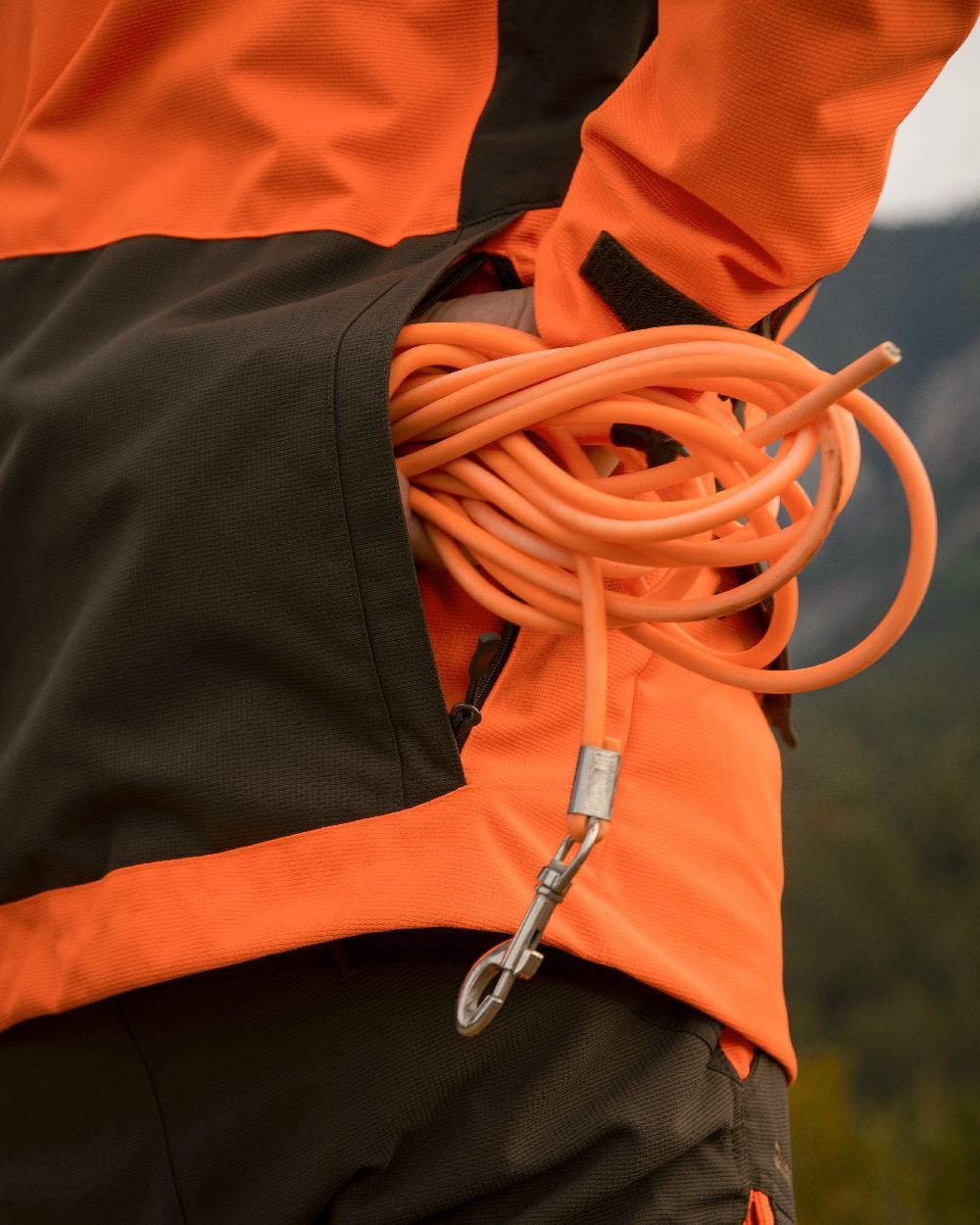 Orange coloured Deerhunter Strike Extreme Waterproof Jacket With Membrane on forest background 