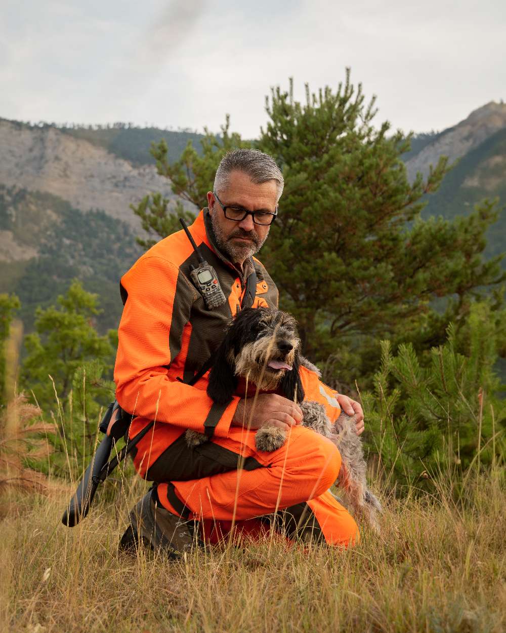 Orange coloured Deerhunter Strike Extreme Waterproof Trousers With Membrane on mountain background 