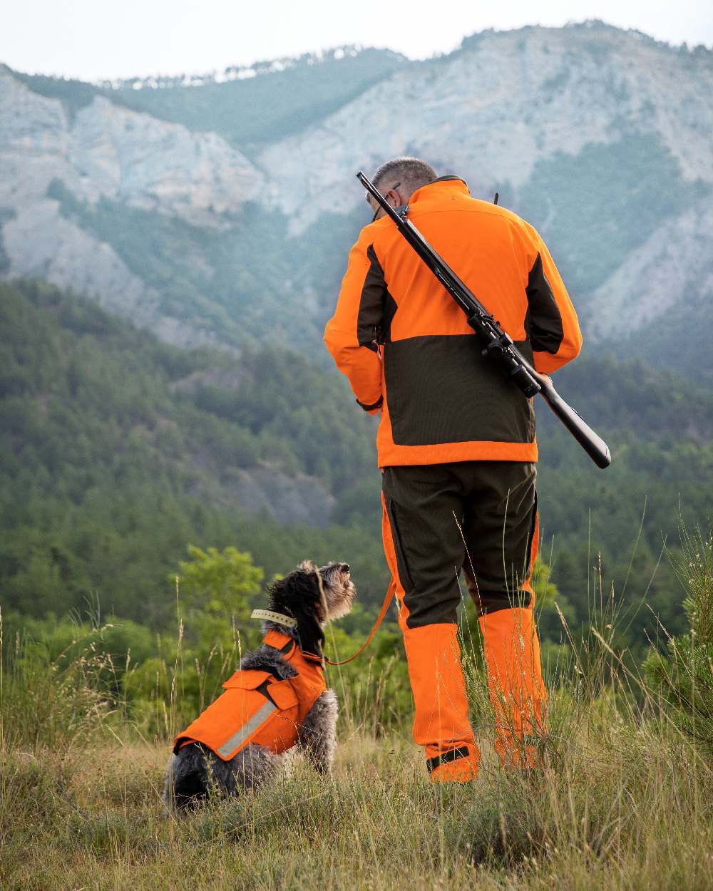 Orange coloured Deerhunter Strike Extreme Waterproof Trousers With Membrane on mountain background 