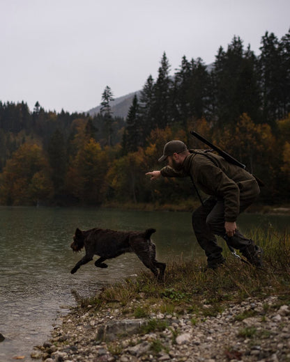 Deep Green coloured Deerhunter Strike Trousers on forest background 