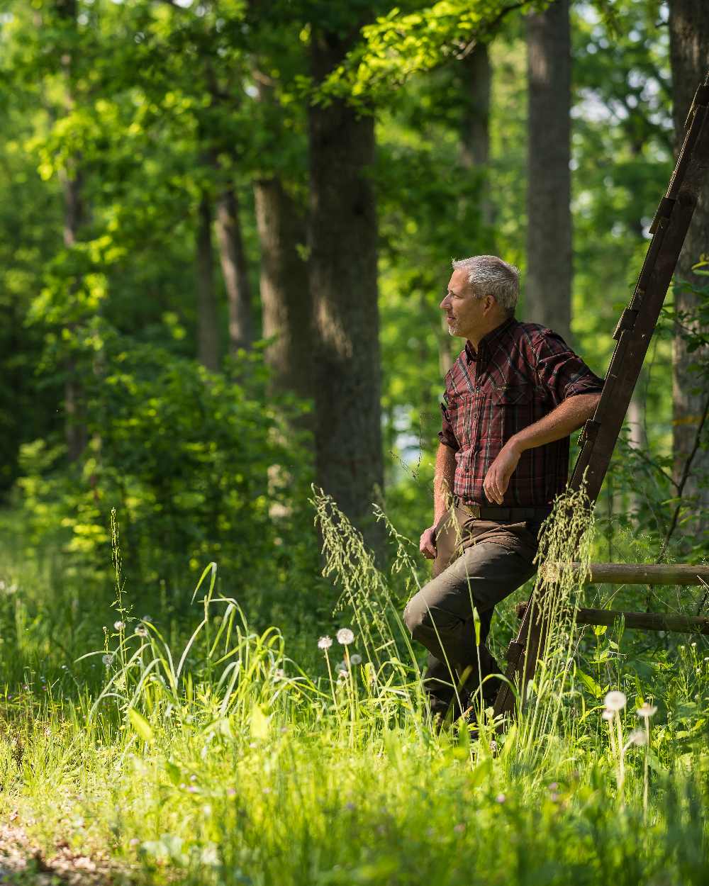 Deep Green coloured Deerhunter Strike Trousers on forest background 