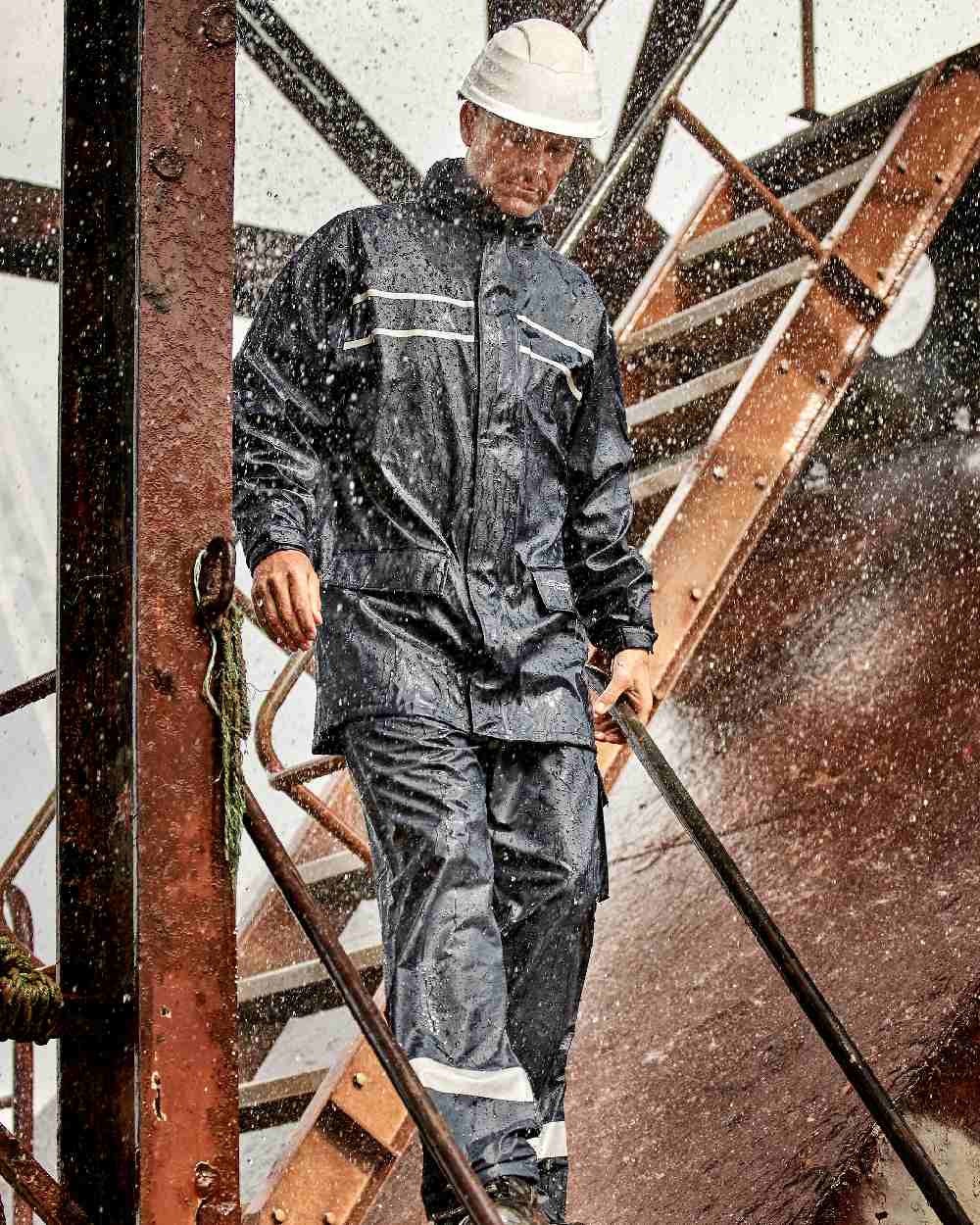 Navy Coloured Elka Mens Dry Zone D-Lux Rain Trousers With Reflective Stripes on construction background 