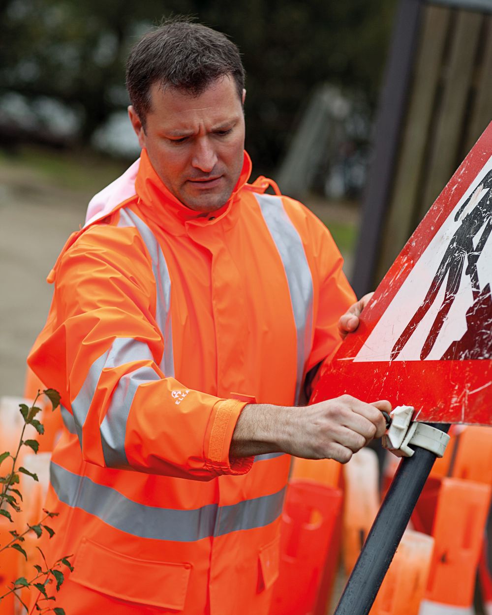 Fluorescent Orange Coloured Elka Mens Dry Zone Visible Jacket Extra Length on blurry background 