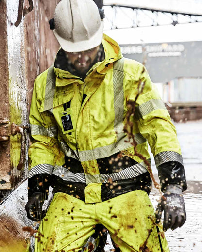 Fluorescent Yellow Black Coloured Elka Mens Visible Xtreme Stretch Jacket on construction background 