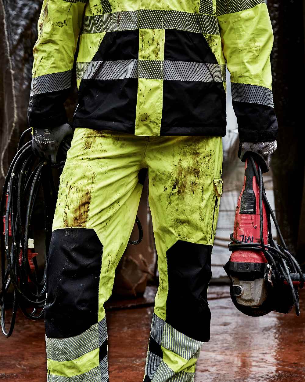 Fluorescent Yellow Black Coloured Elka Mens Visible Xtreme Stretch Waist Trousers on construction background 