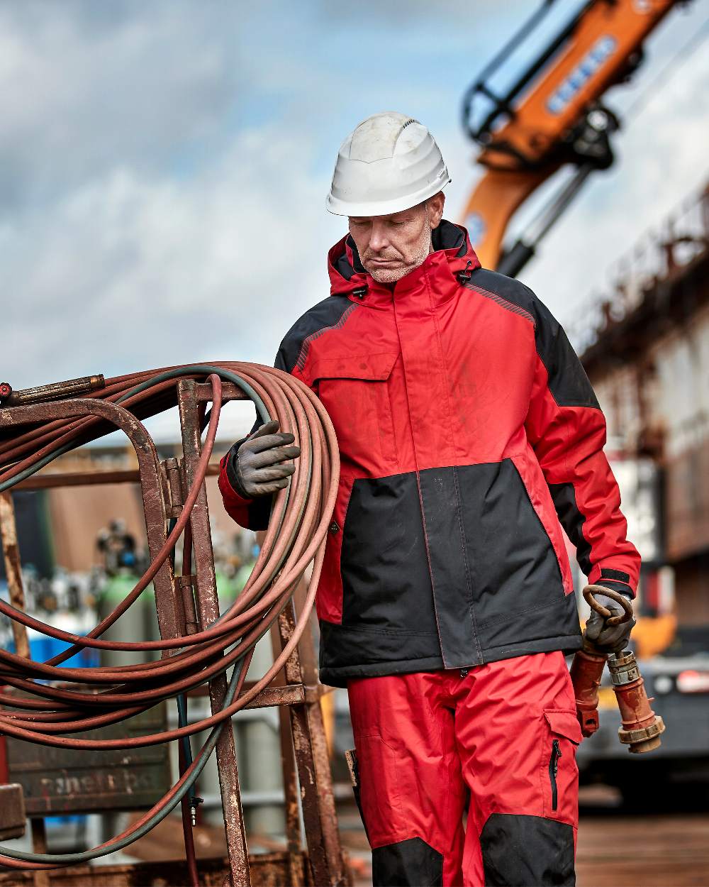 Red Black Coloured Elka Mens Working Xtreme Stretch Winter Jacket on construction background 