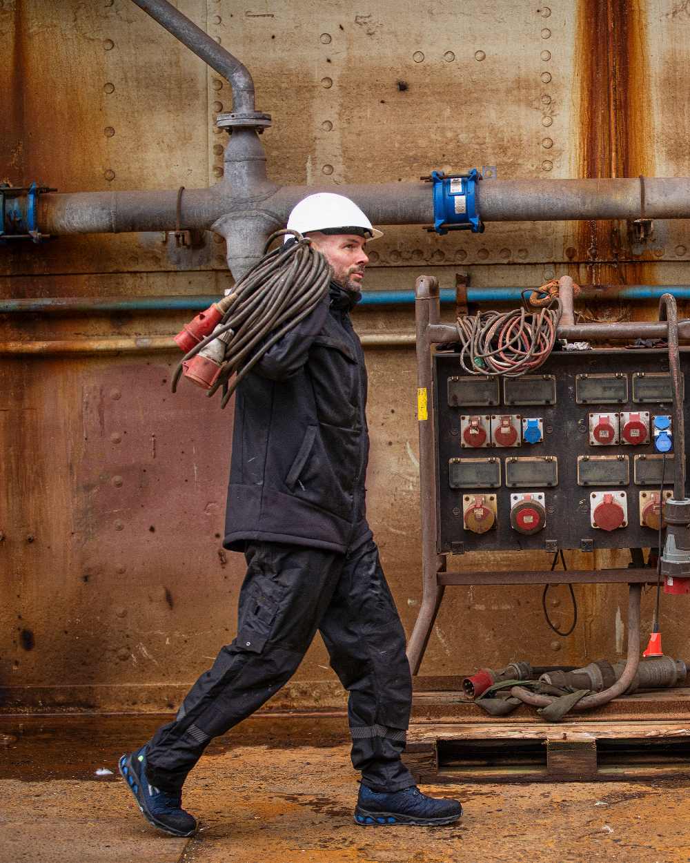 Black Coloured Elka Mens Working Xtreme Winter Softshell Jacket on construction background 