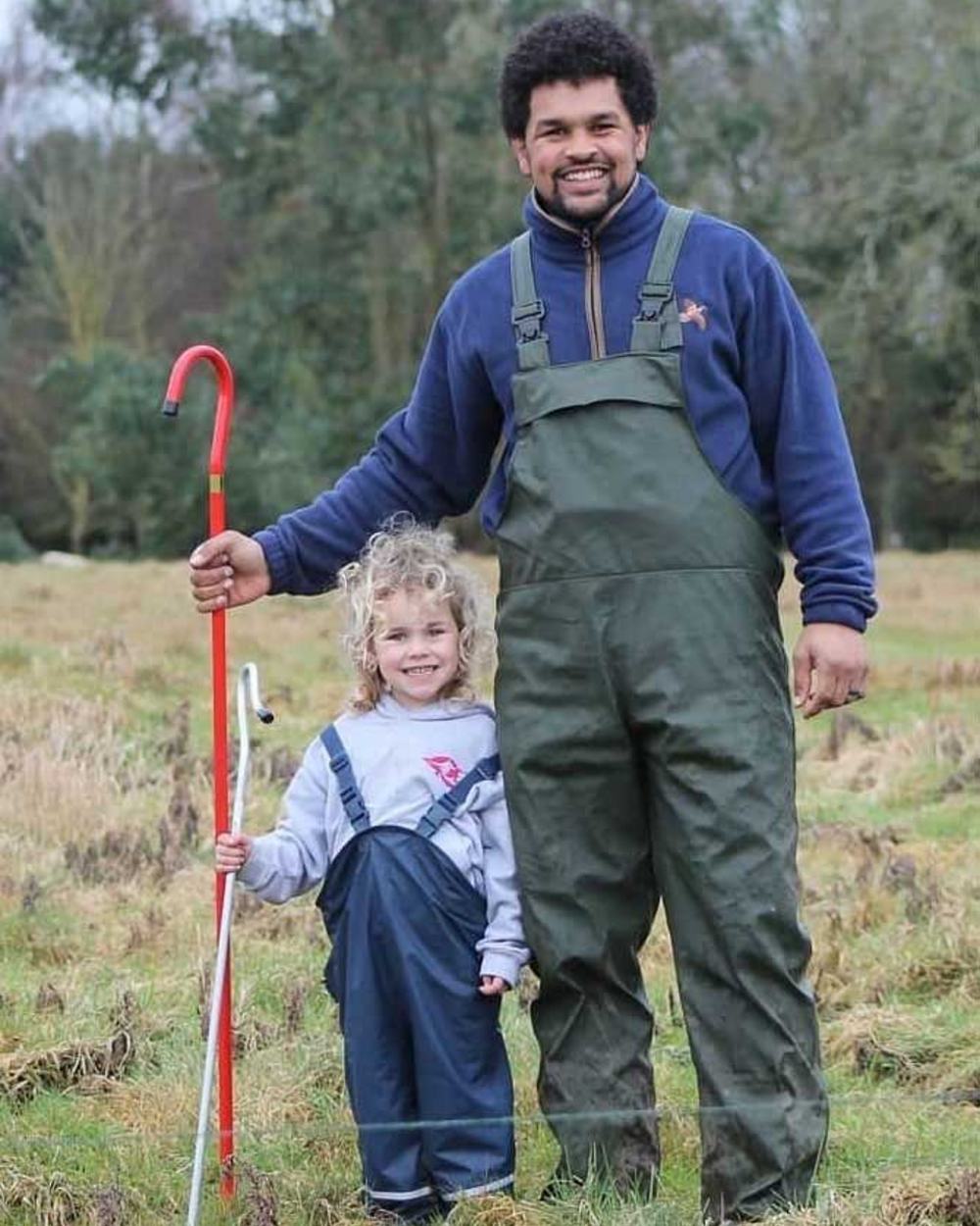 Olive coloured Fort Airflex Waterproof Breathable Bib and Brace Overalls on field background 