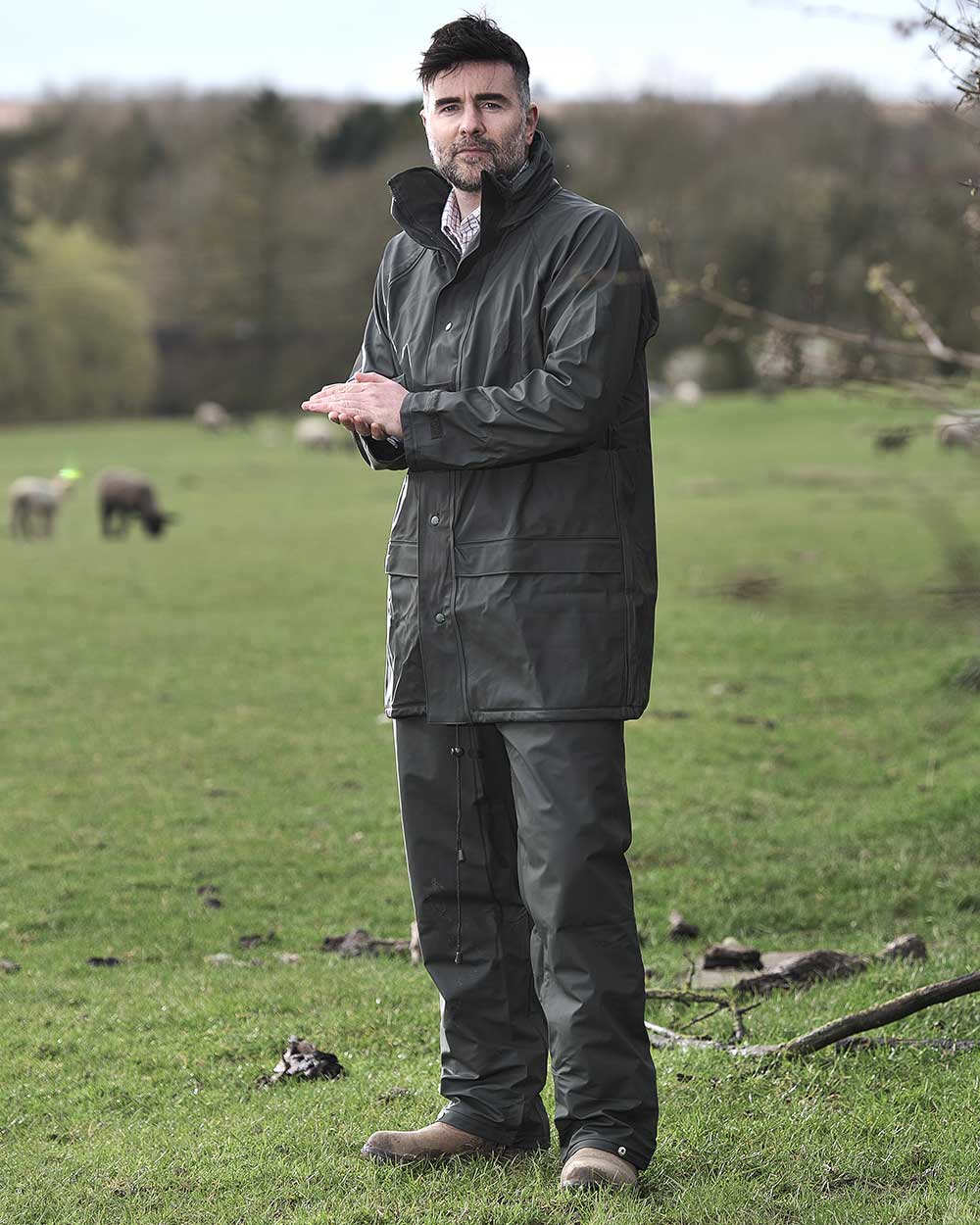 Green coloured Fort Fortex Flex Waterproof Trousers on blurry green background 