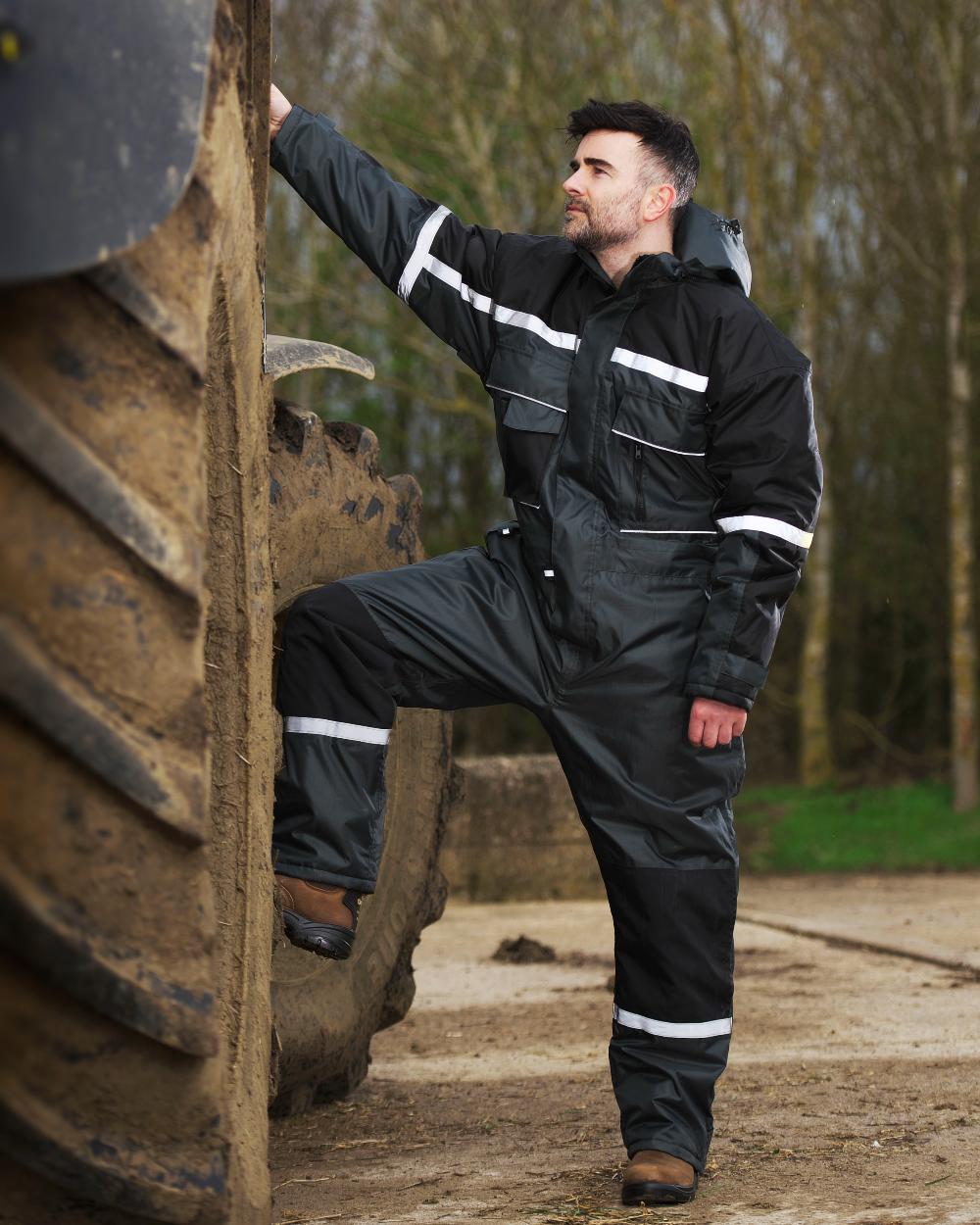 Green coloured Fort Orwell Waterproof Padded Boilersuit on blurry background 