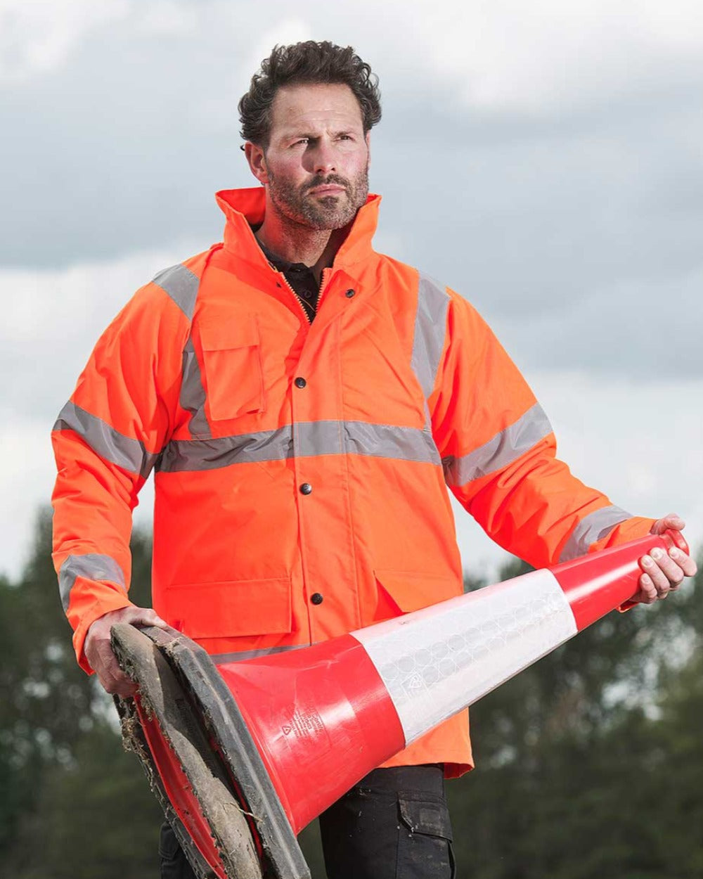 Orange coloured Fort Workwear Hi-Vis Quilted Jacket on blurry background 