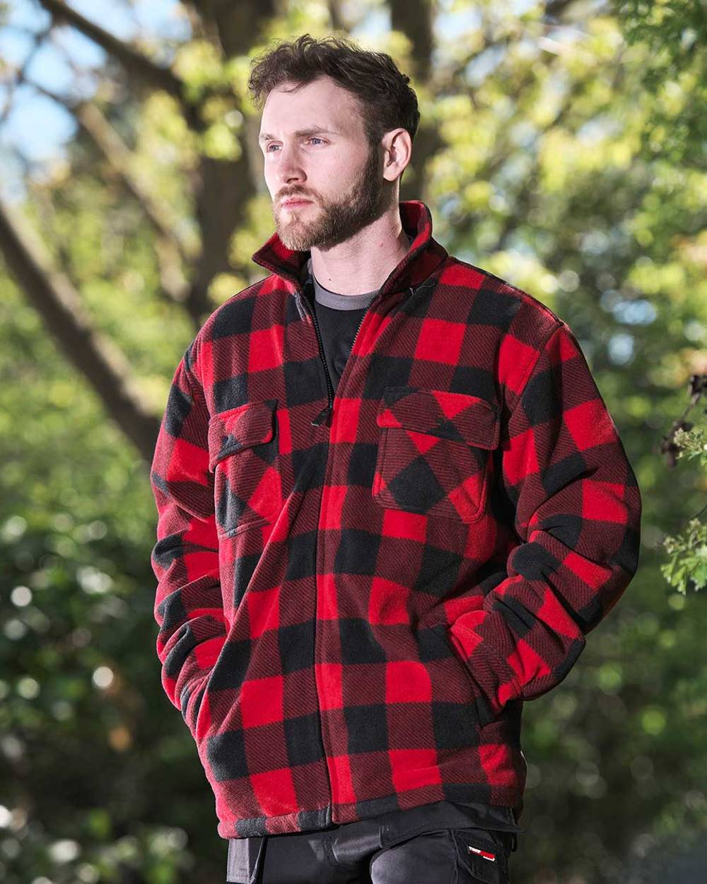 Red coloured Fort Portman Fleece Jacket on blurry green background 