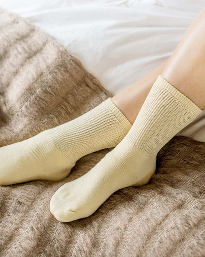 Oatmeal coloured HJ Hall Cotton Rich Diabetic Socks on bed background 