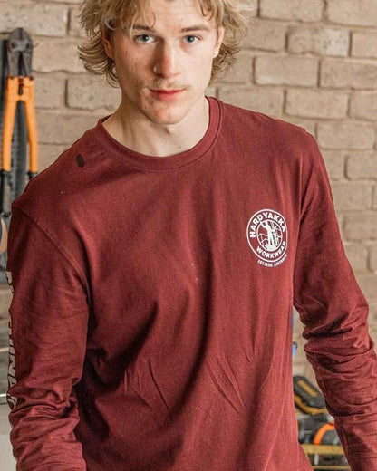 Burgundy coloured Hard Yakka Heritage Long Sleeve T-Shirt on house background 