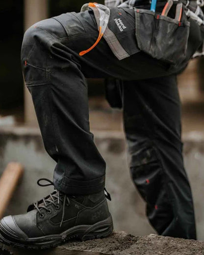 Black coloured Hard Yakka Legend S3 Safety Boots on outdoor background 