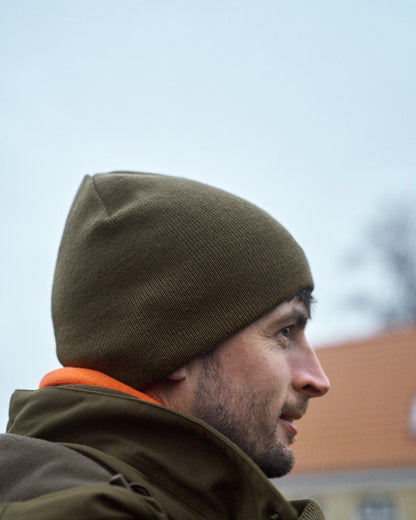 Willow Green Orange Coloured Harkila Reversible Beanie on outdoor background 