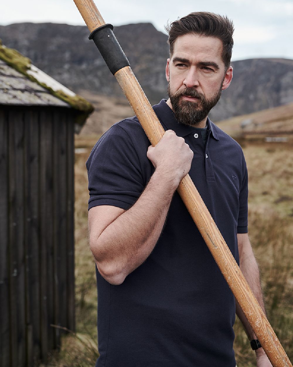 Navy Coloured Hoggs of Fife Largs Pique Polo Shirt on mountain background 