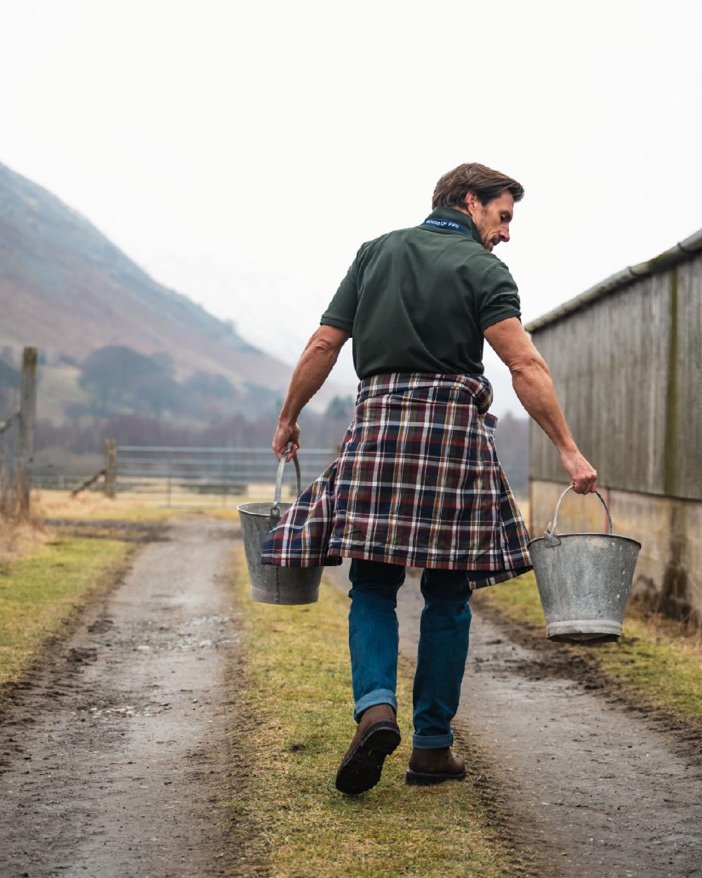 Forest Coloured Hoggs of Fife Mens Newton Pique Polo Shirt on countryside background 