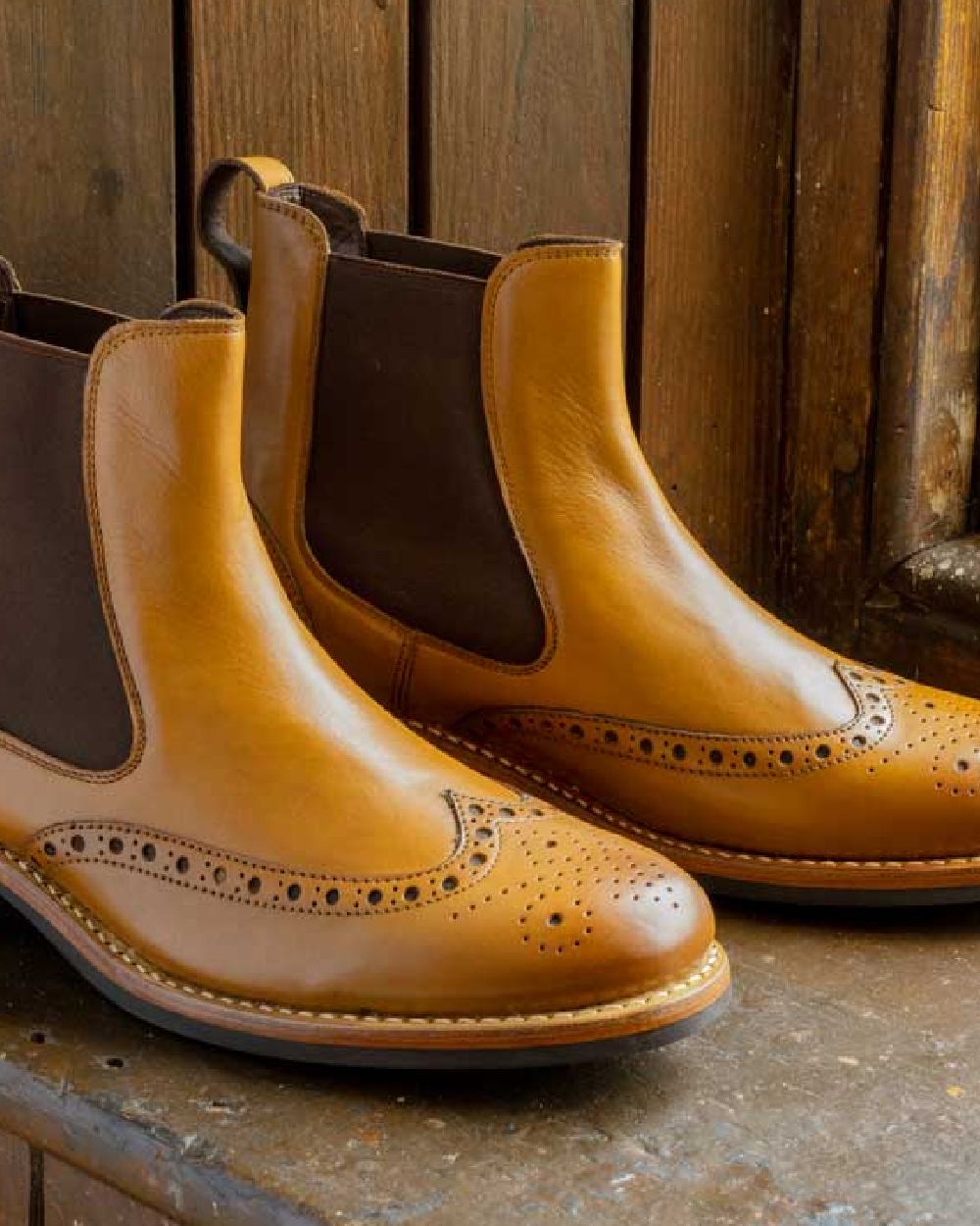 Burnished Tan Coloured Hoggs of Fife Stanley Semi-Brogue Dealer Boots on wood background 