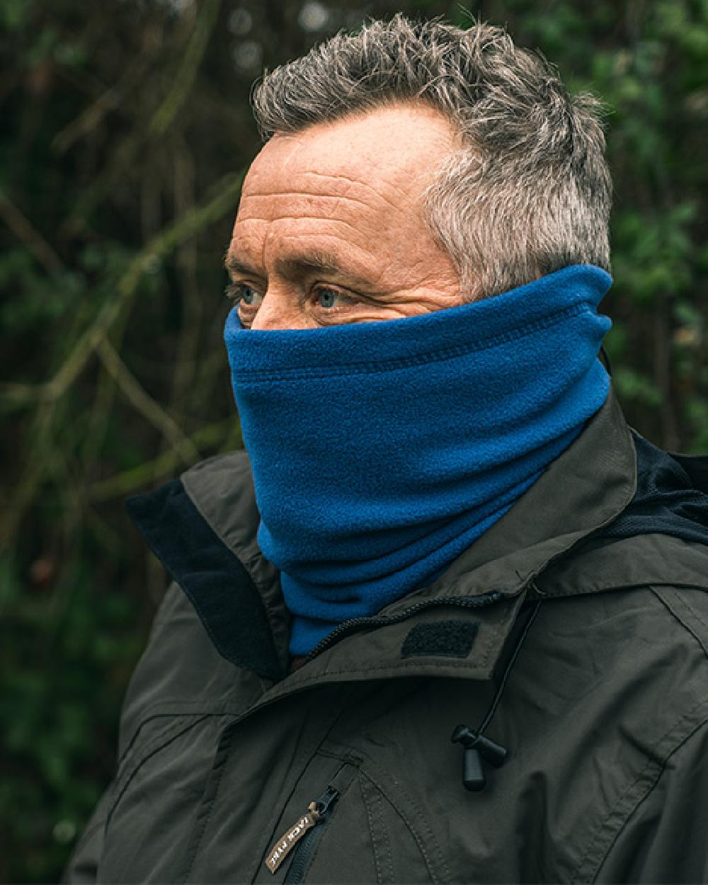 Denim coloured Jack Pyke Country Fleece Neck Gaiter on forest background