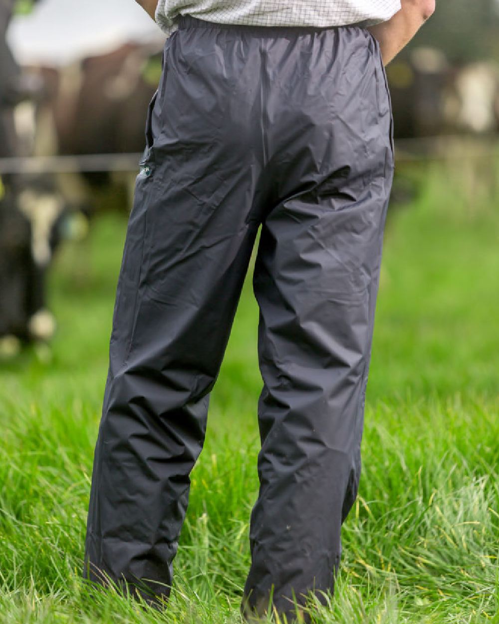 Navy coloured Kaiwaka Mens AgTex Overtrousers on grassy background 