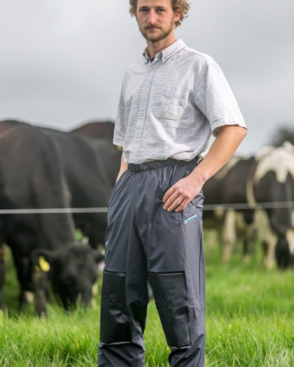 Navy coloured Kaiwaka Mens AgTex Overtrousers on grassy background 