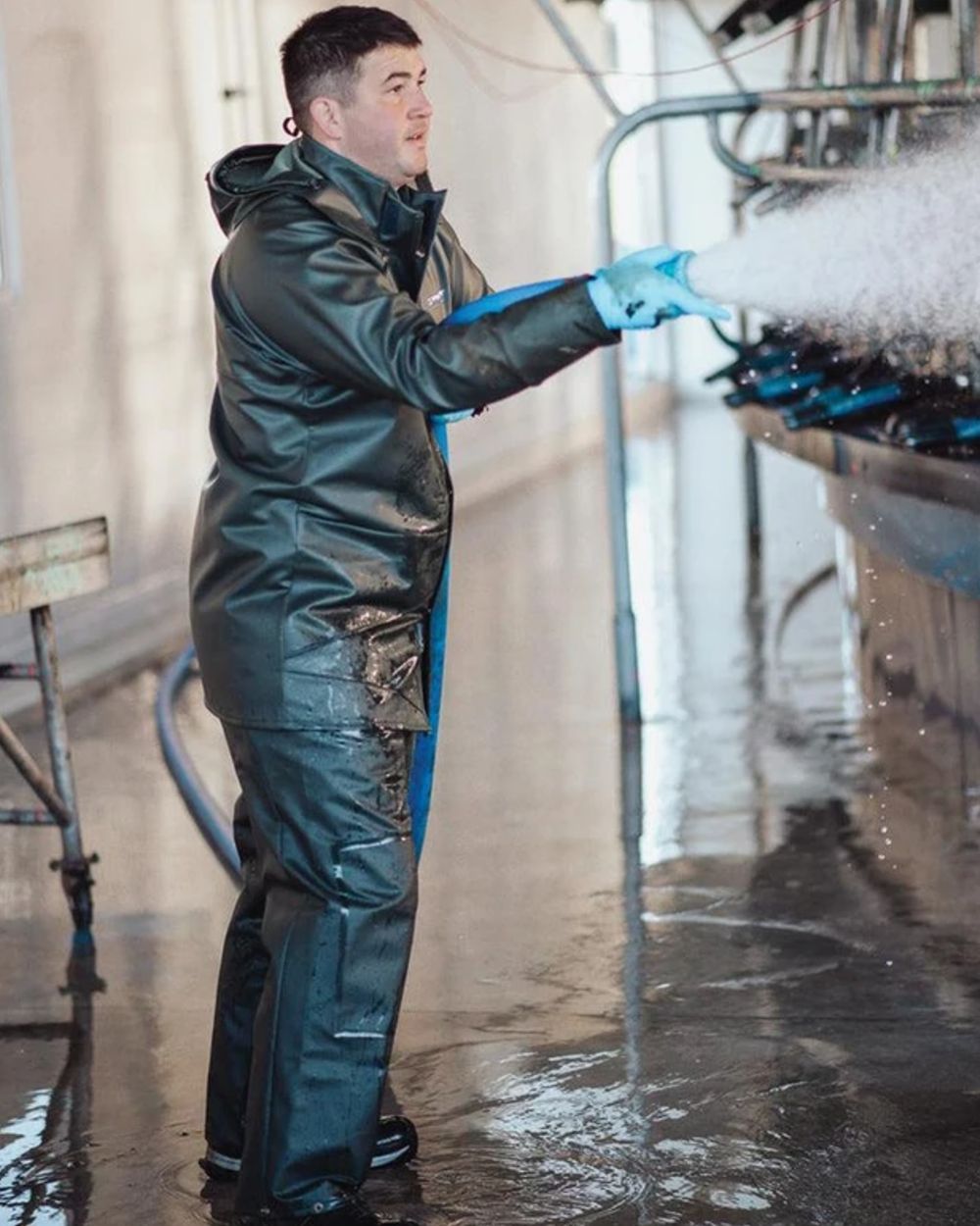 Green coloured Kaiwaka Mens Dairytex Overtrousers on factory background 