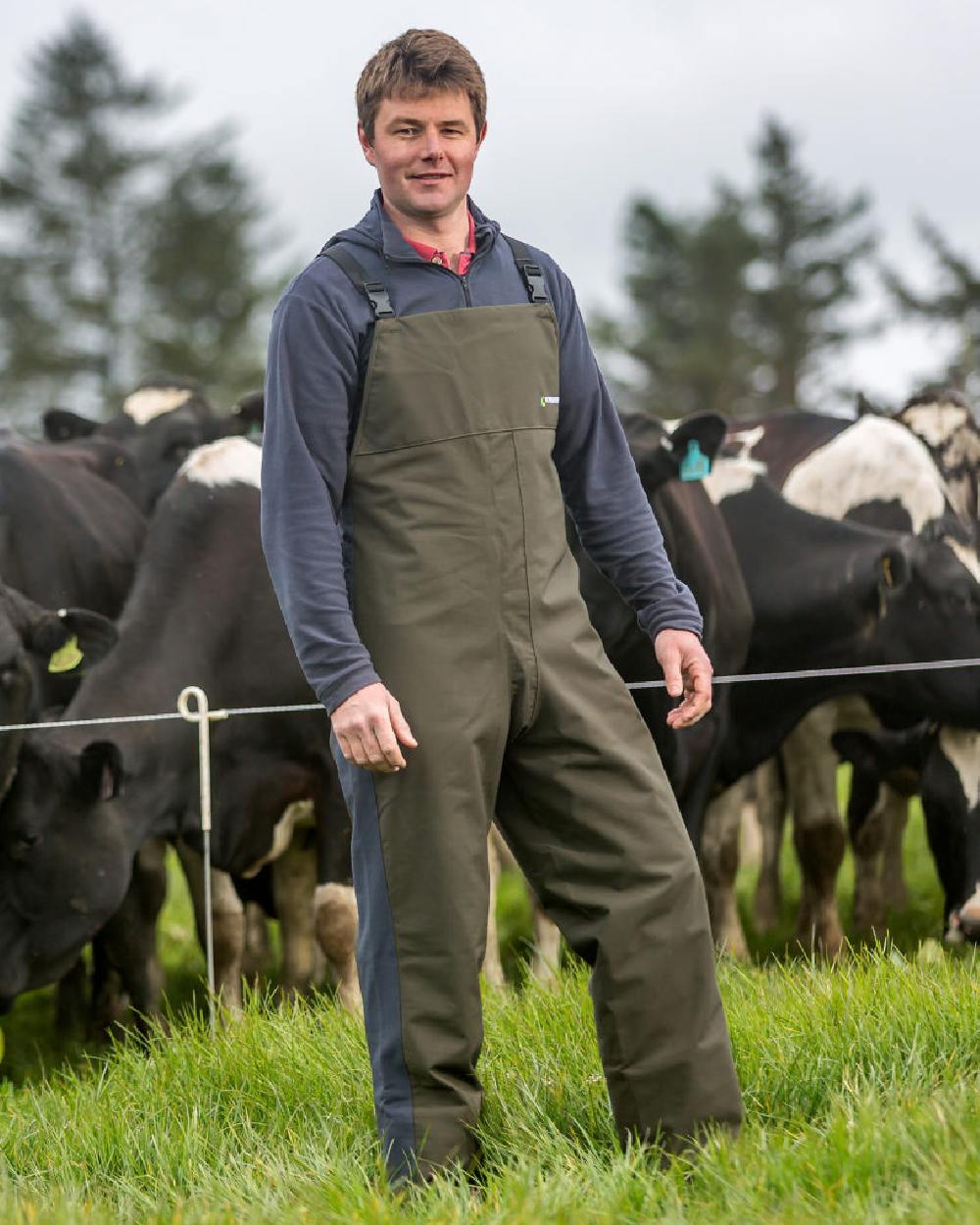 Olive coloured Kaiwaka Mens Stormforce Bib Overtrousers on grassy background 