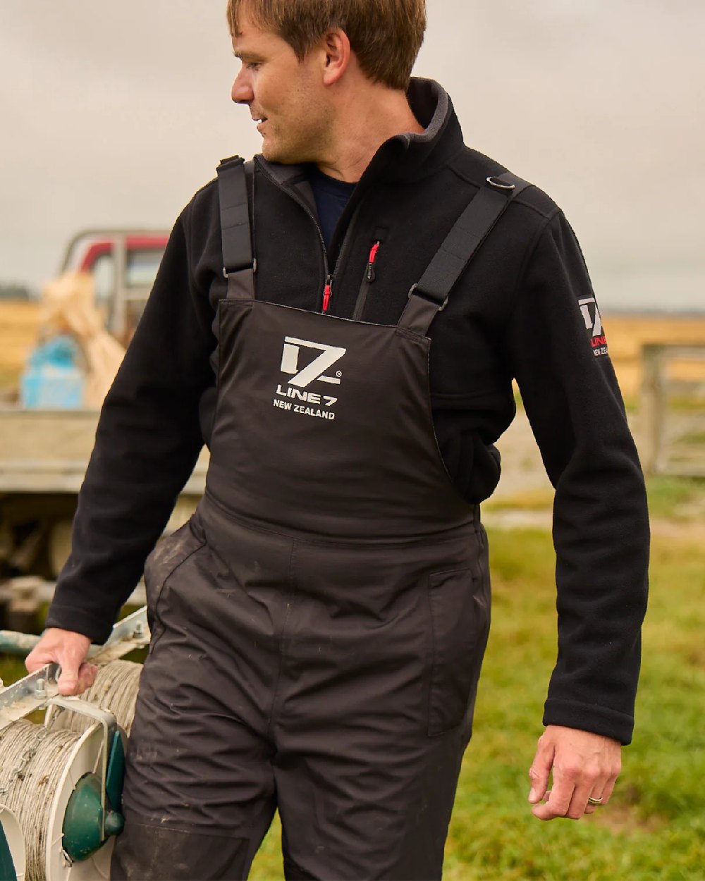 Black Coloured Line 7 Mens Storm Pro 20 Bib Pant V2 on farm background 