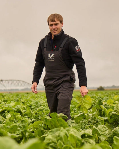 Black Coloured Line 7 Mens Territory Storm Pro20 Waterproof Bib Overtrouser on farm background 