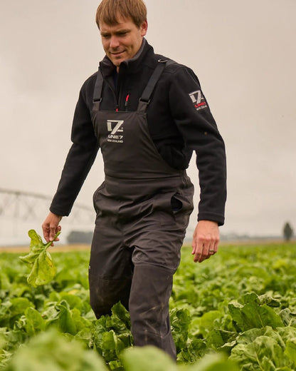 Black Coloured Line 7 Mens Territory Storm Pro20 Waterproof Bib Overtrouser on farm background 