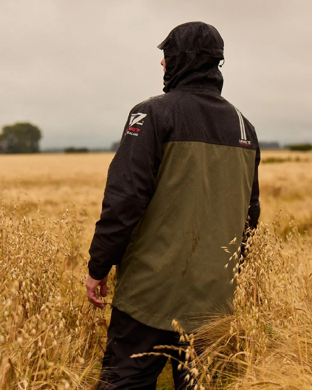Moss Black Coloured Line 7 Mens Territory Storm Pro20 Waterproof Jacket on farm background 