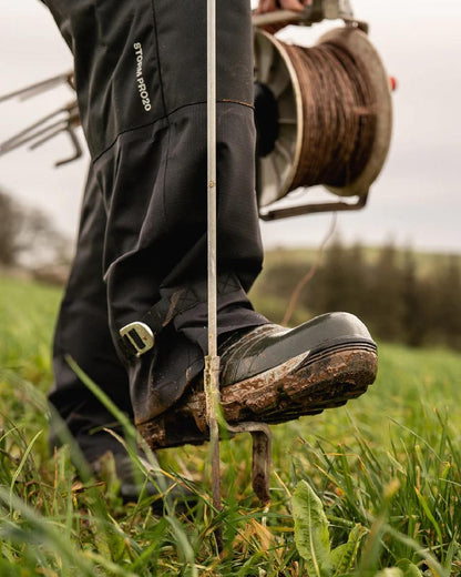 Black coloured Line 7 Mens Territory Storm Pro20 Waterproof Overtrouser on farm background 