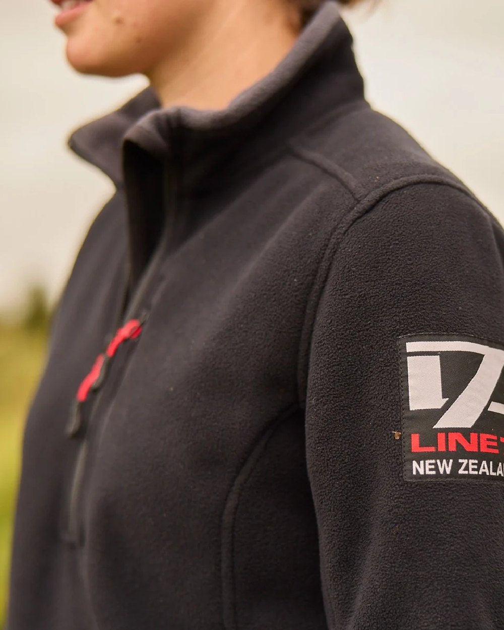 Black Coloured Line 7 Womens Territory Wind Pro Half Zip Fleece Jacket on blurry background 