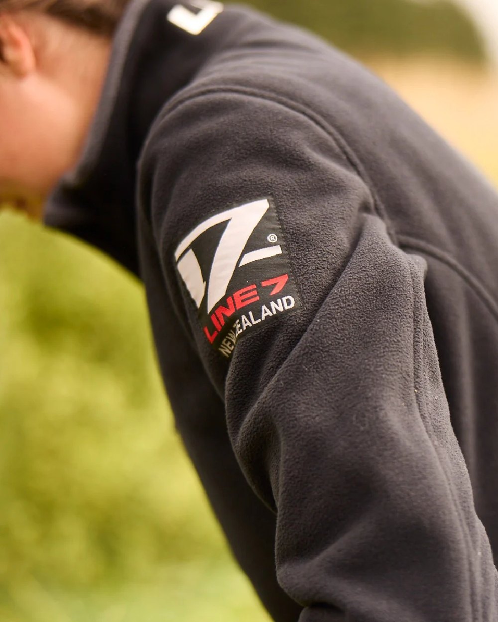 Black Coloured Line 7 Womens Territory Wind Pro Half Zip Fleece Jacket on blurry background 