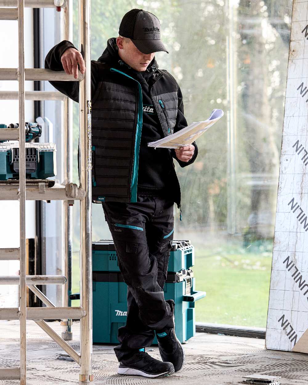 Black Coloured Makita Mens Vector Stretch Trousers on outdoor background 