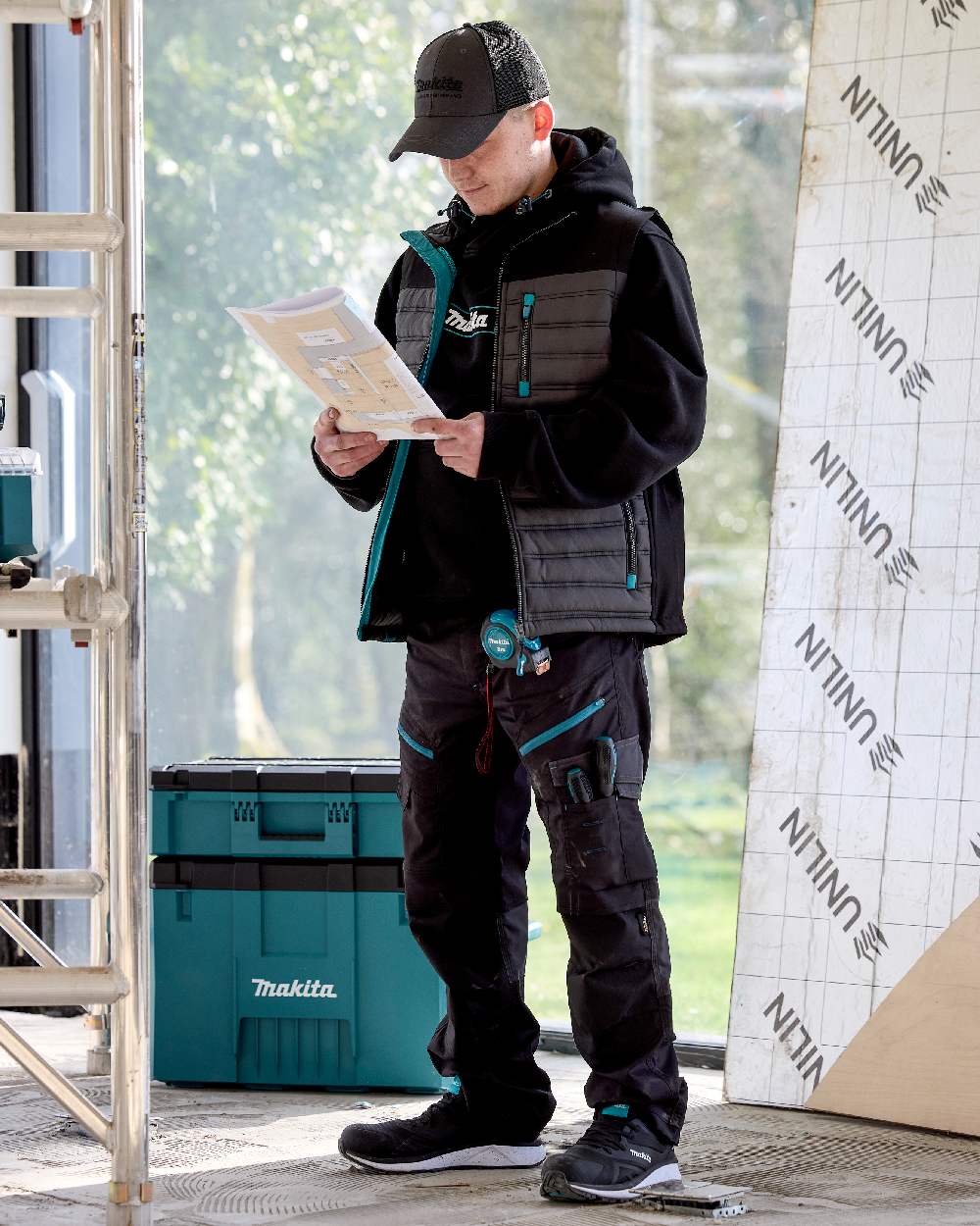Black Coloured Makita Mens Vector Stretch Trousers on outdoor background 