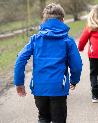 Azure Blue Dark Navy Coloured Mascot Workwear Childrens Accelerate Lightweight Outer Shell Jacket on outdoor background 