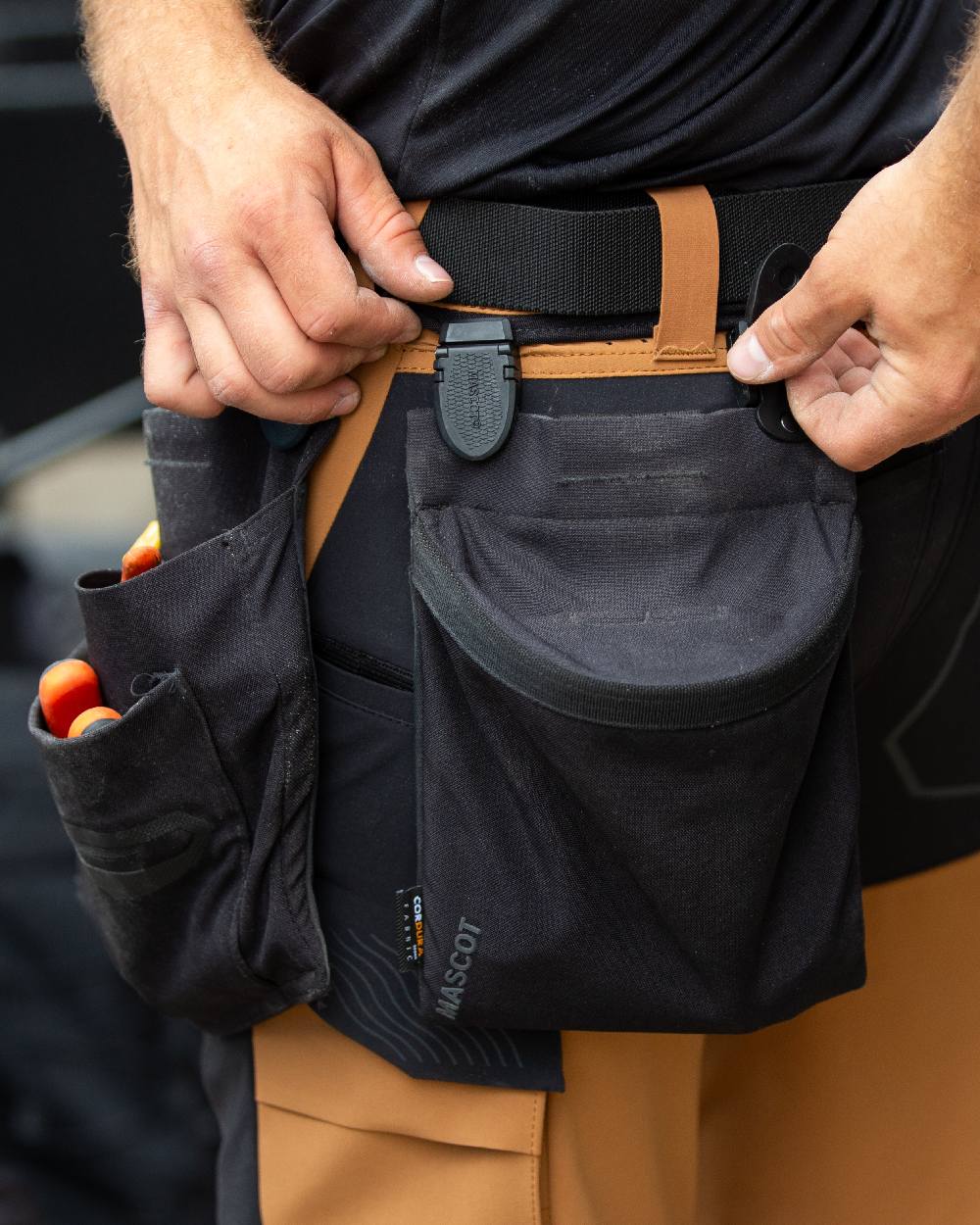 Black Coloured Mascot Workwear Customized Click System Magnet Closure Holster Pocket on construction background 
