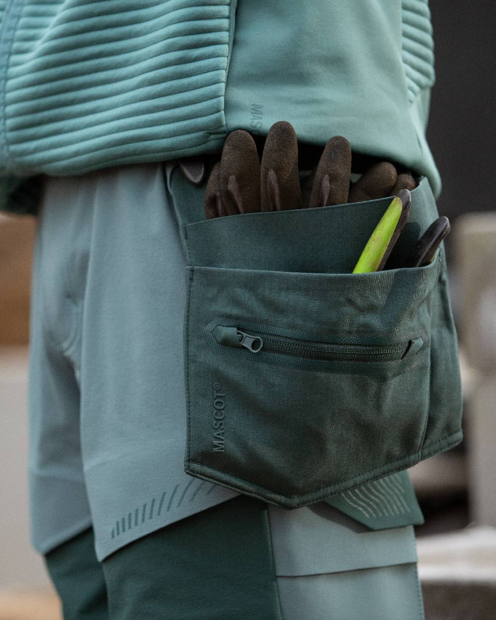 Forest Green Coloured Mascot Workwear Customized Craftsman Holster Pockets on construction background 
