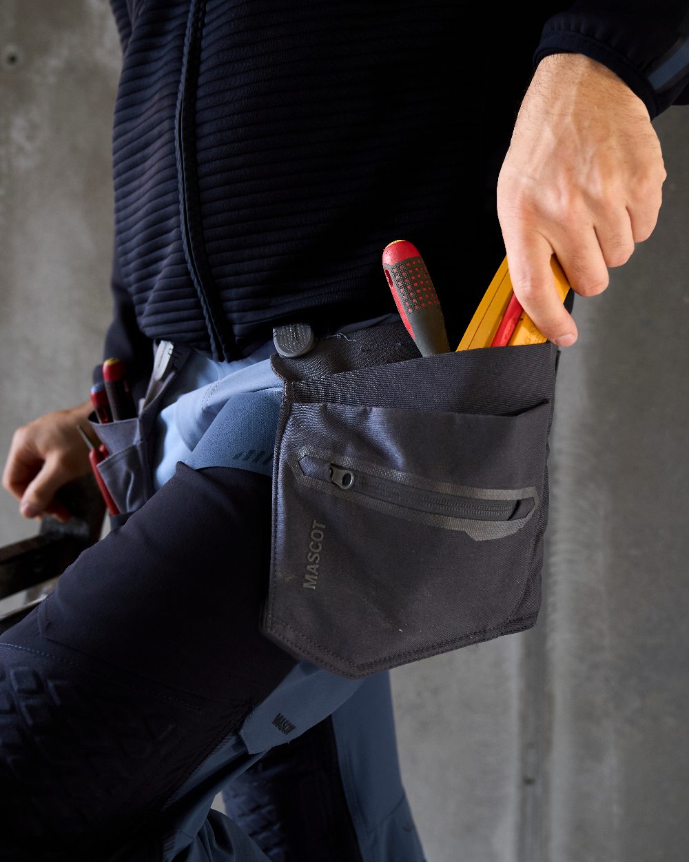 Dark Navy Coloured Mascot Workwear Customized Electrician Holster Pockets on construction background 