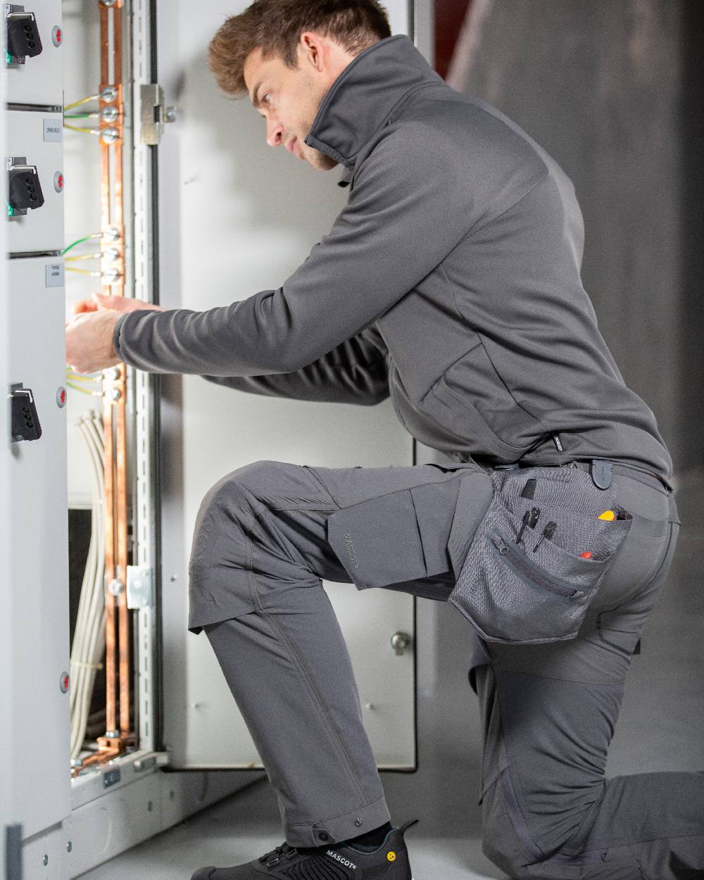 Stone Grey Coloured Mascot Workwear Customized Electrician Holster Pockets on construction background 