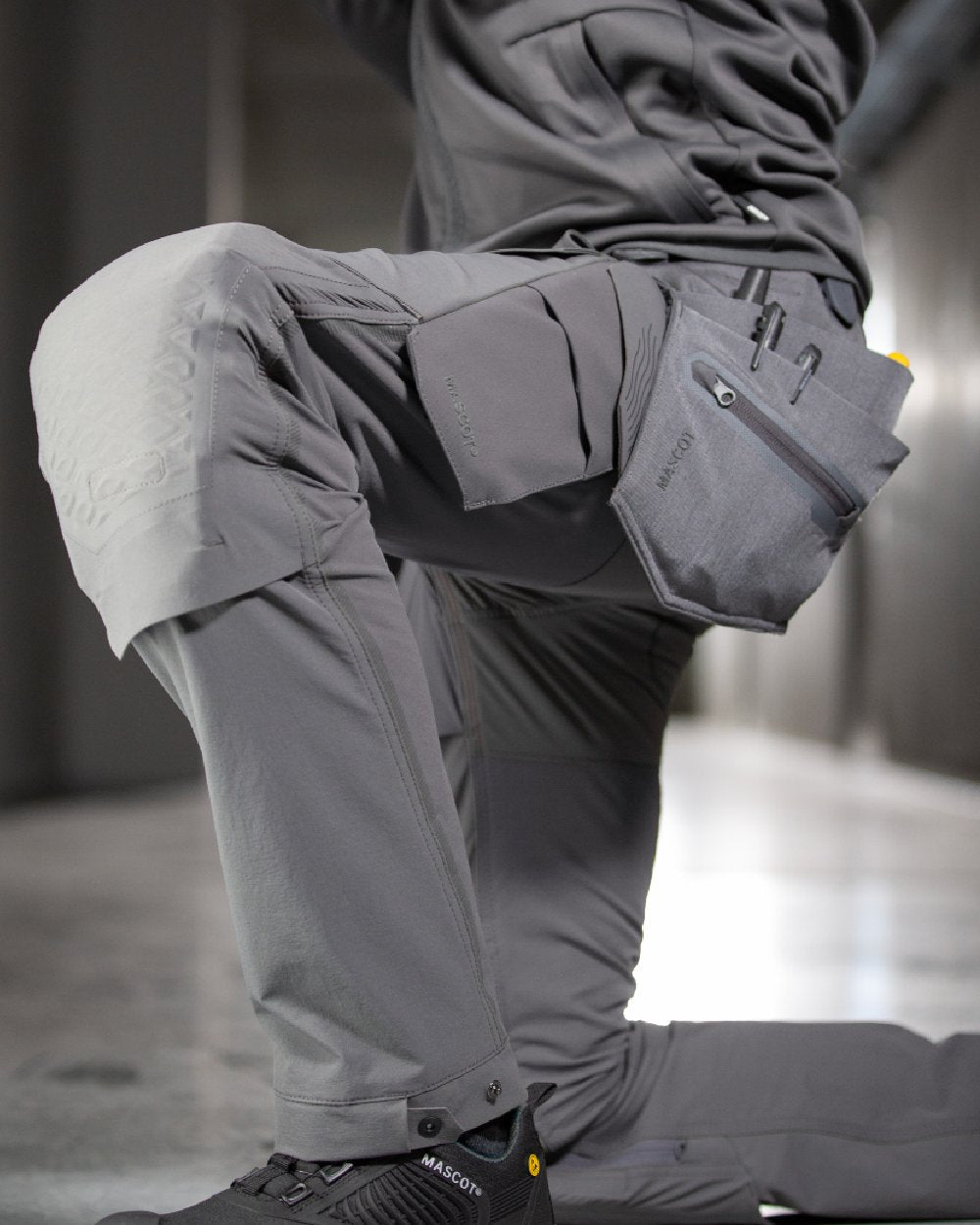 Stone Grey Coloured Mascot Workwear Customized Electrician Holster Pockets on construction background 