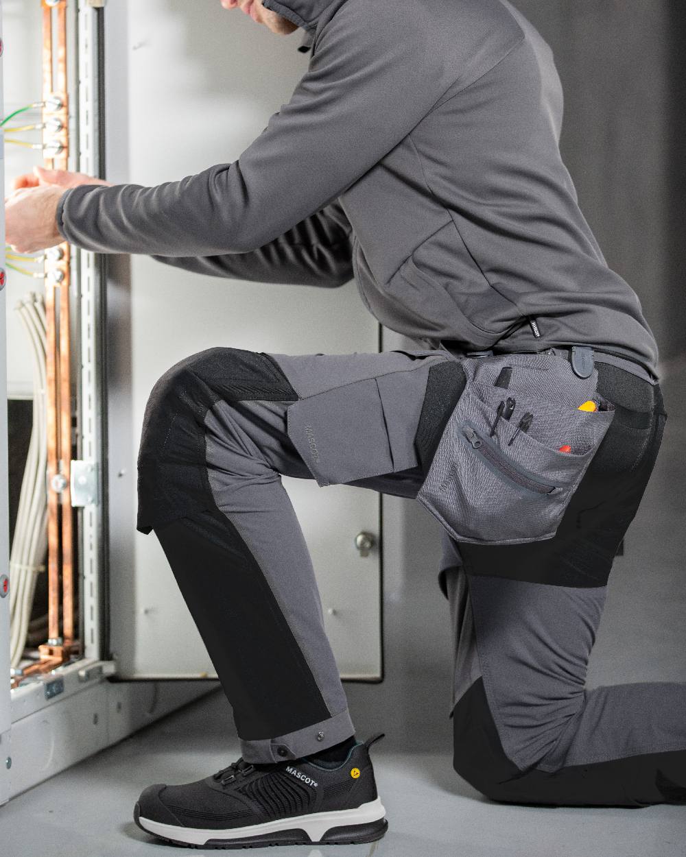Stone Grey Coloured Mascot Workwear Customized Electrician Holster Pockets on construction background 